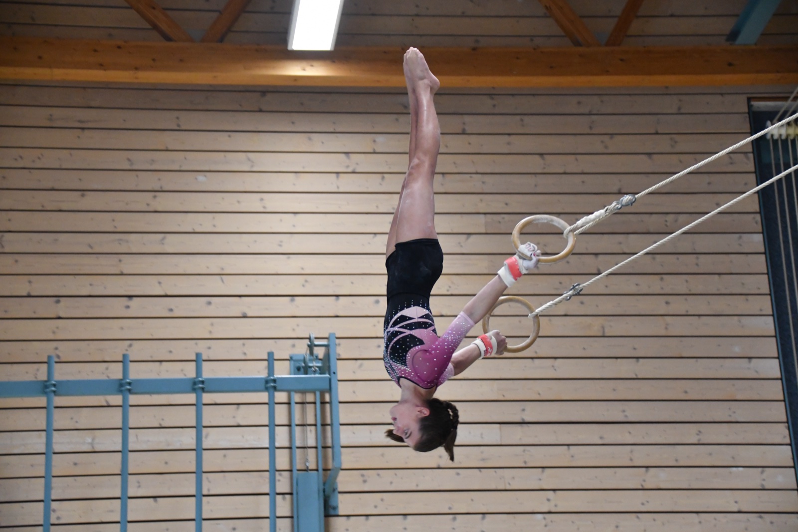 Geräteturnerinnen beim Training an Reck, Schaukelringen und Sprung