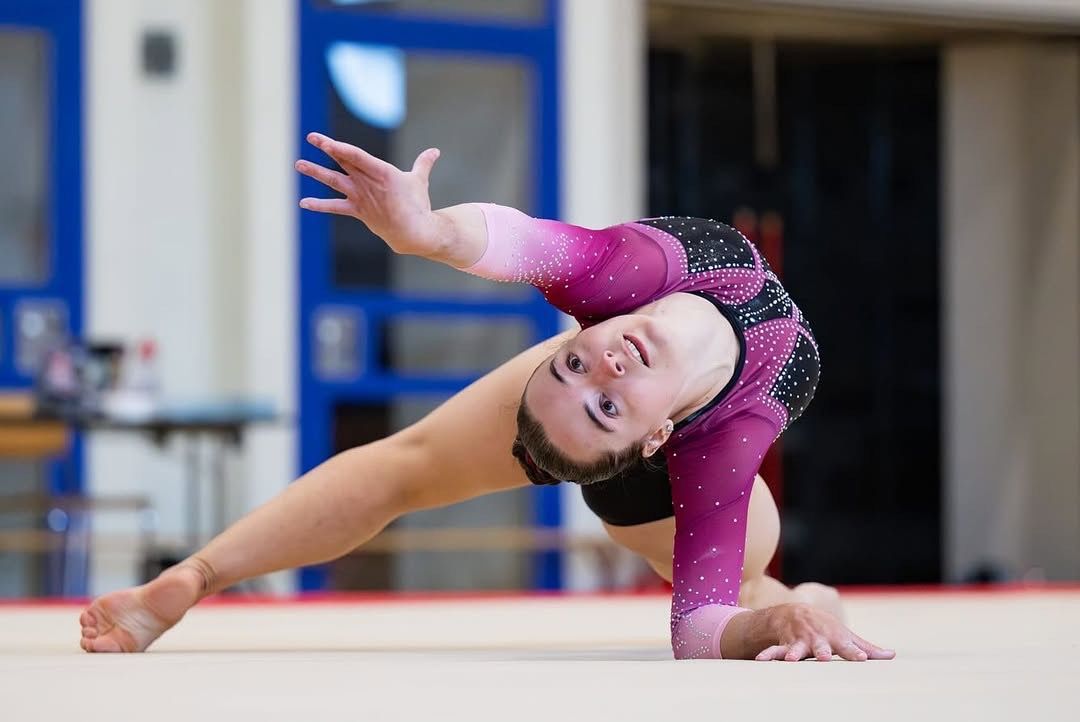 Kunstturnerin in akrobatischer Brücke-Pose